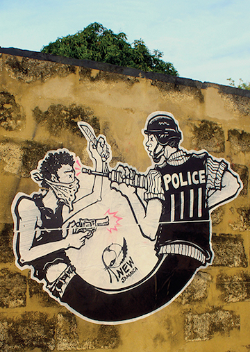 Photograph of street art depicting a police officer and a scarfed figure.