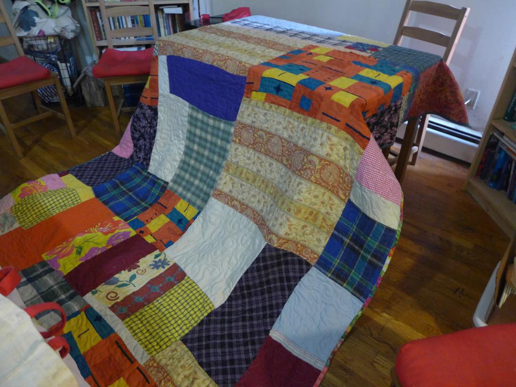 "colorful patchwork quilt draped over table"